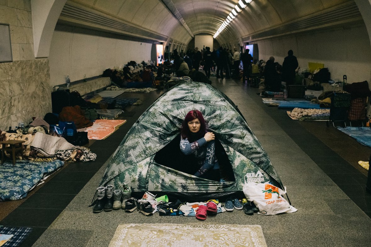 campierende Menschen in einer Halle